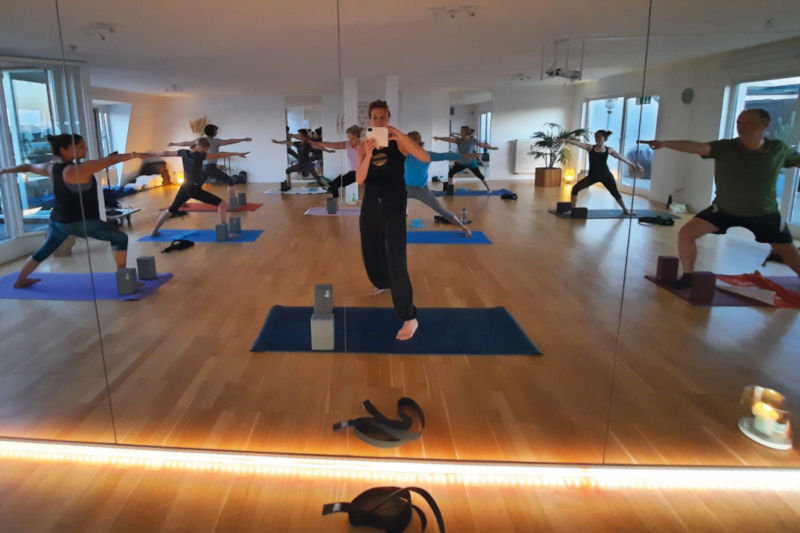 Gruppe bei einer Yogaeinheit mit ruhigen Bewegungsfolgen